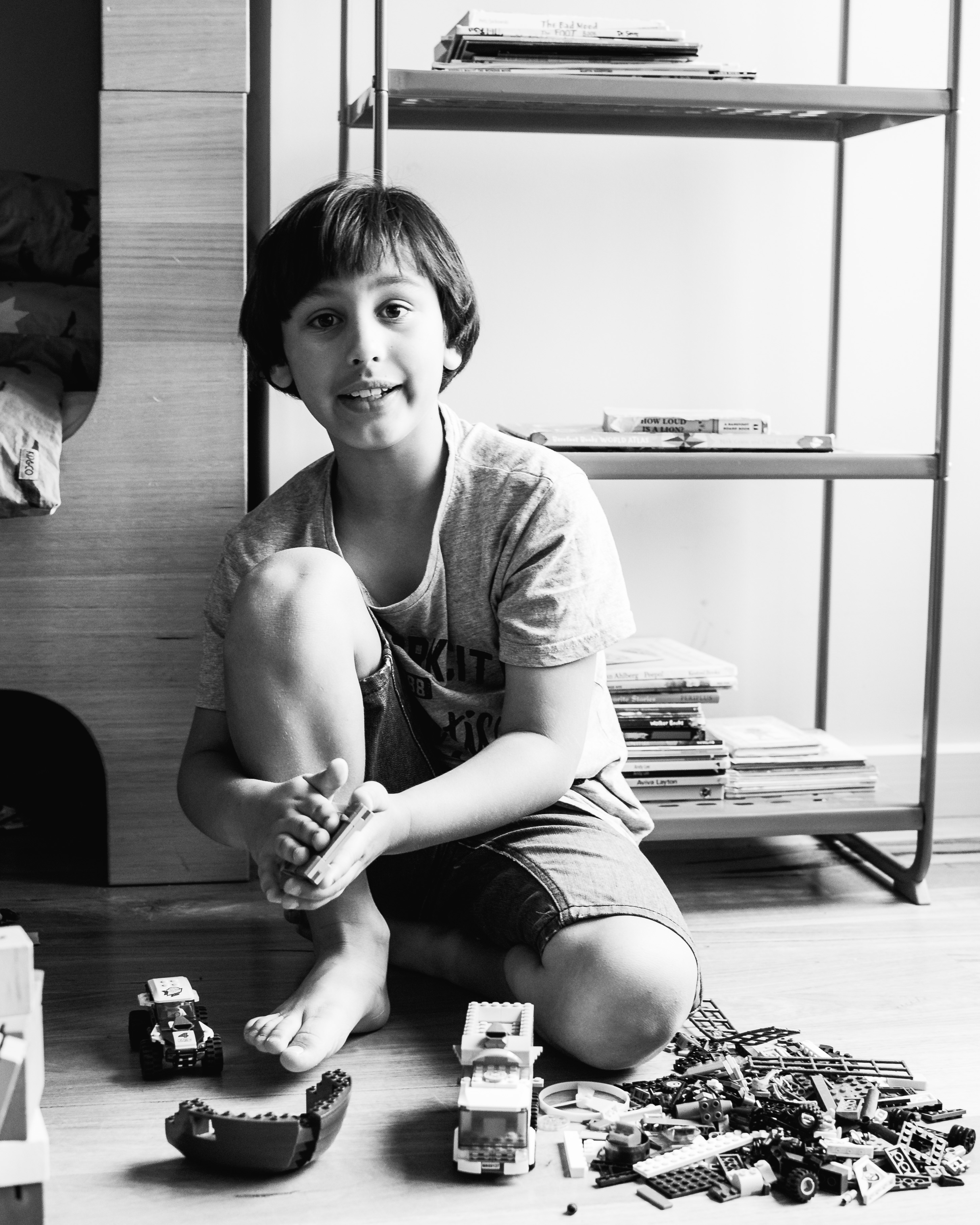 photograph of a boy talking while creating and building with Lego in his bedroom in Carlton North, Melbourne, Australia