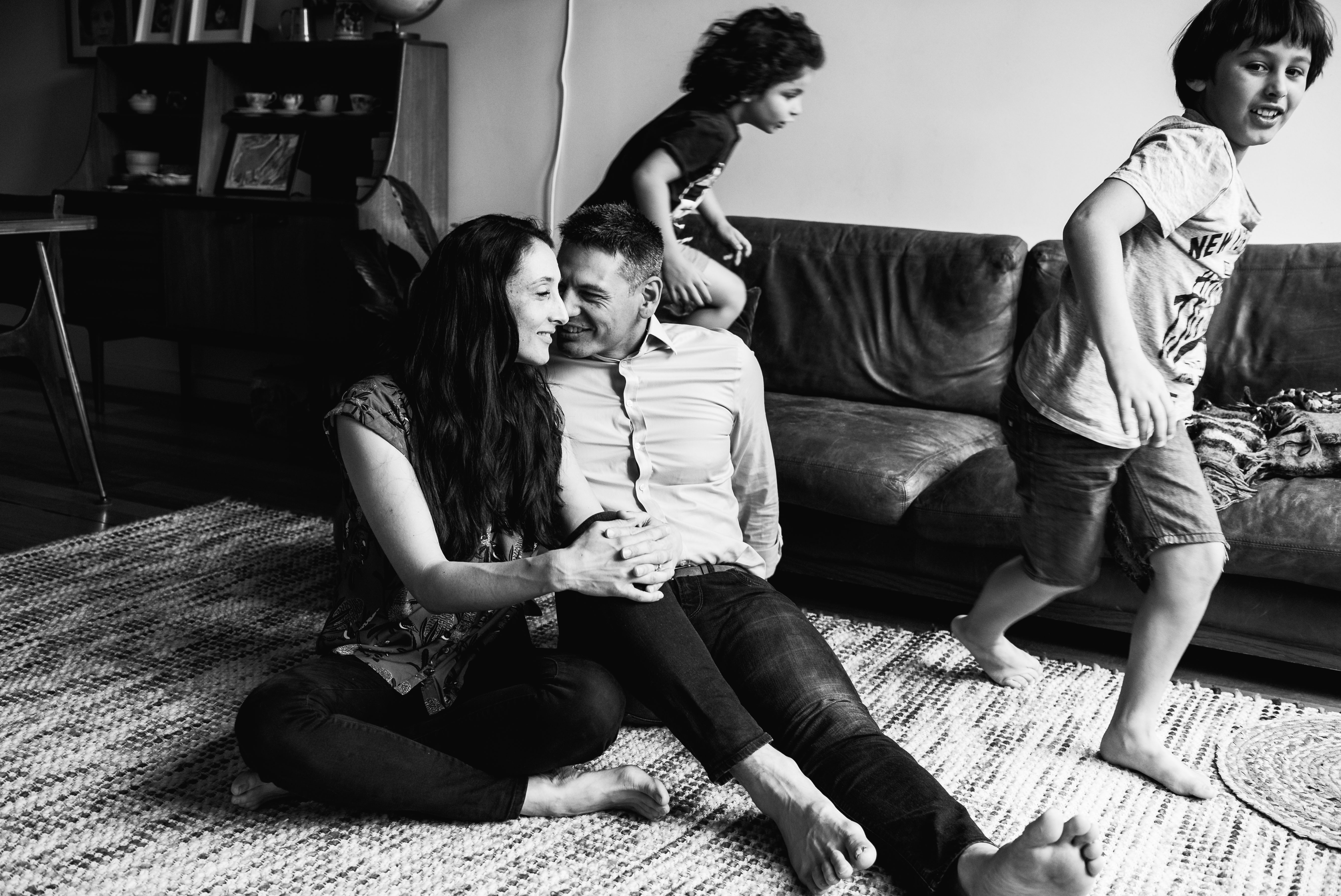 photograph of parents talking and laughing as boys run around in circles in Carlton North, Melbourne, Australia