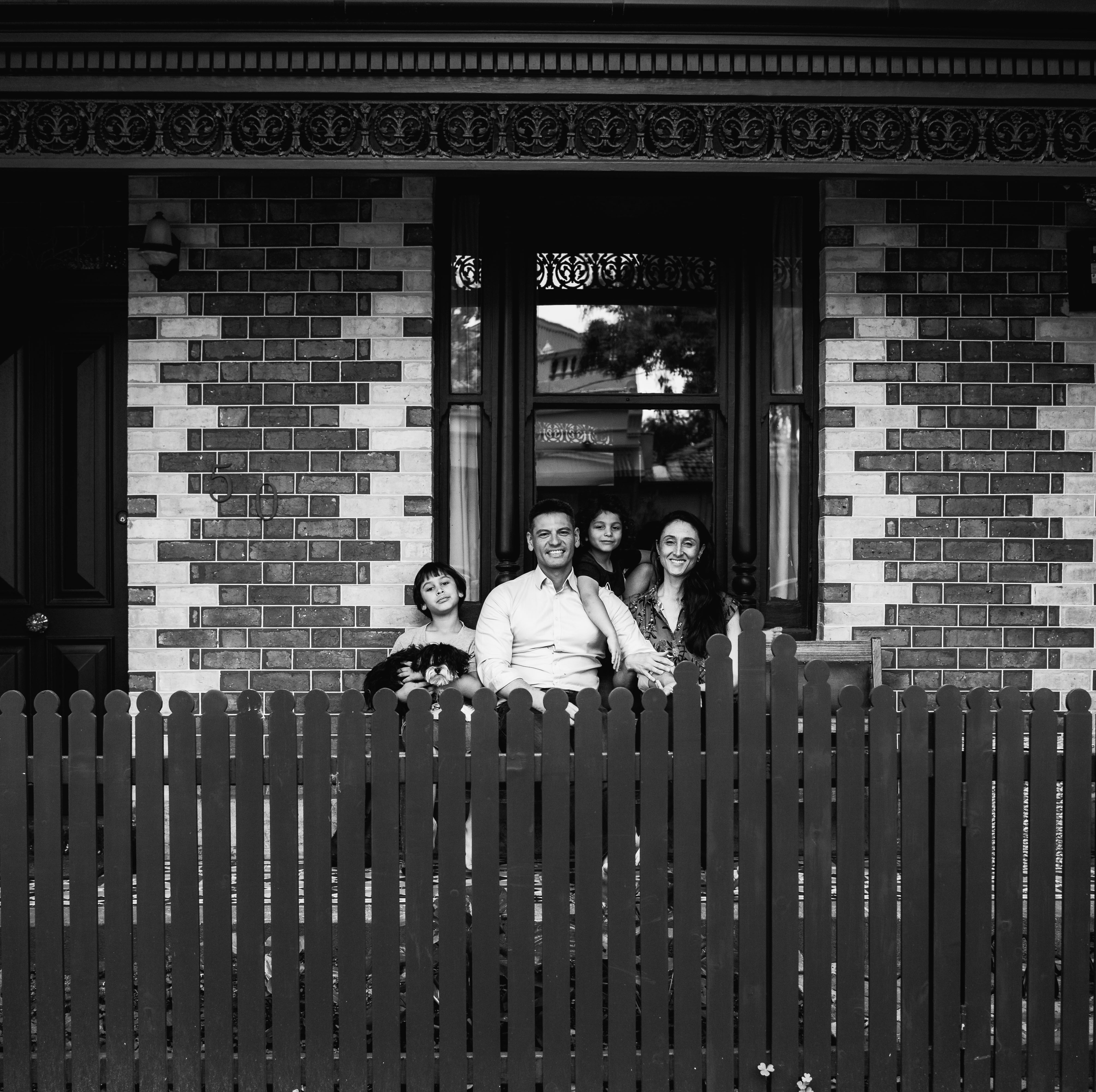 photograph of a family sitting at the front of their home in Carlton North, Melbourne, Australia