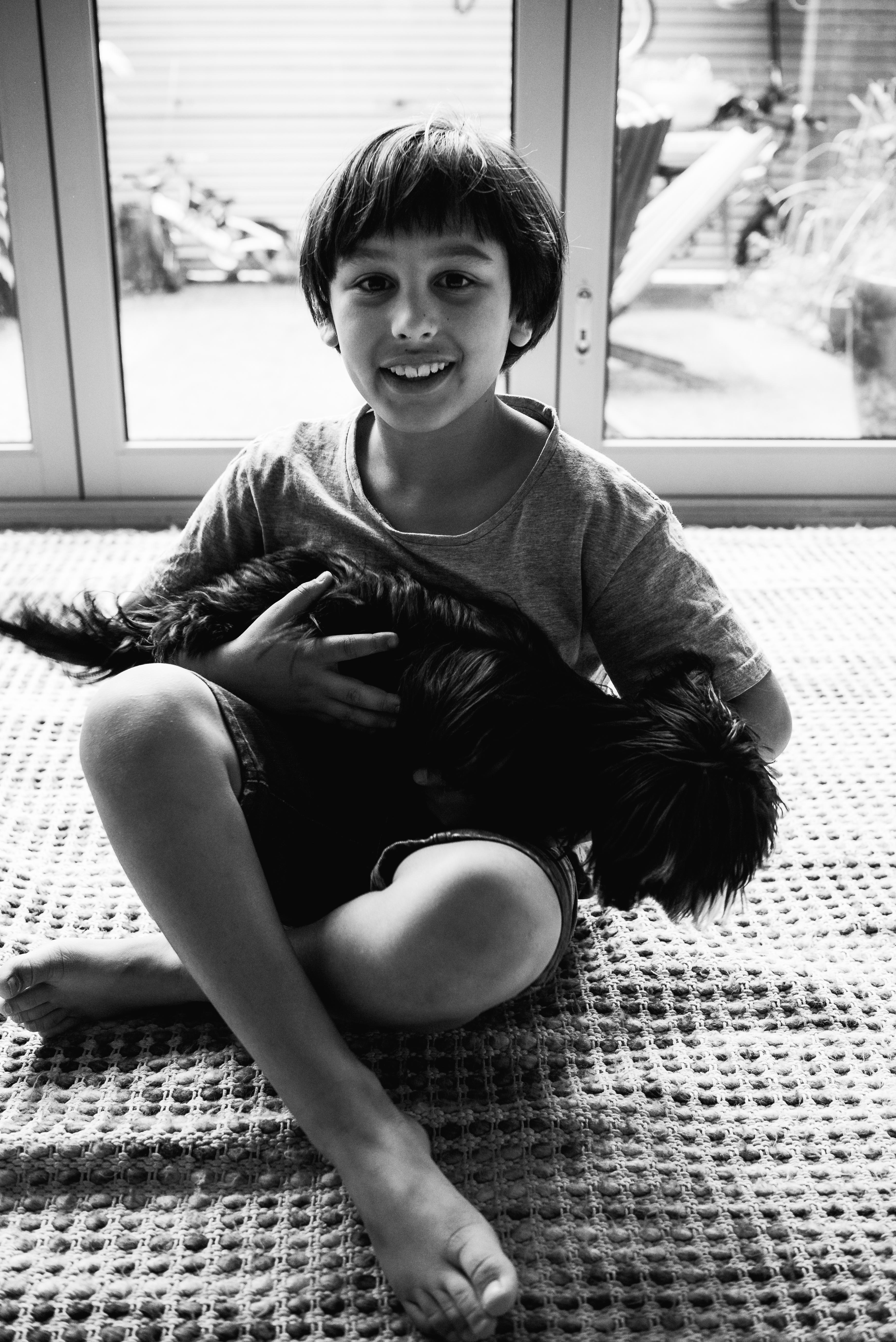 photograph of a boy and his cute dog cuddling in Carlton North, Melbourne, Australia