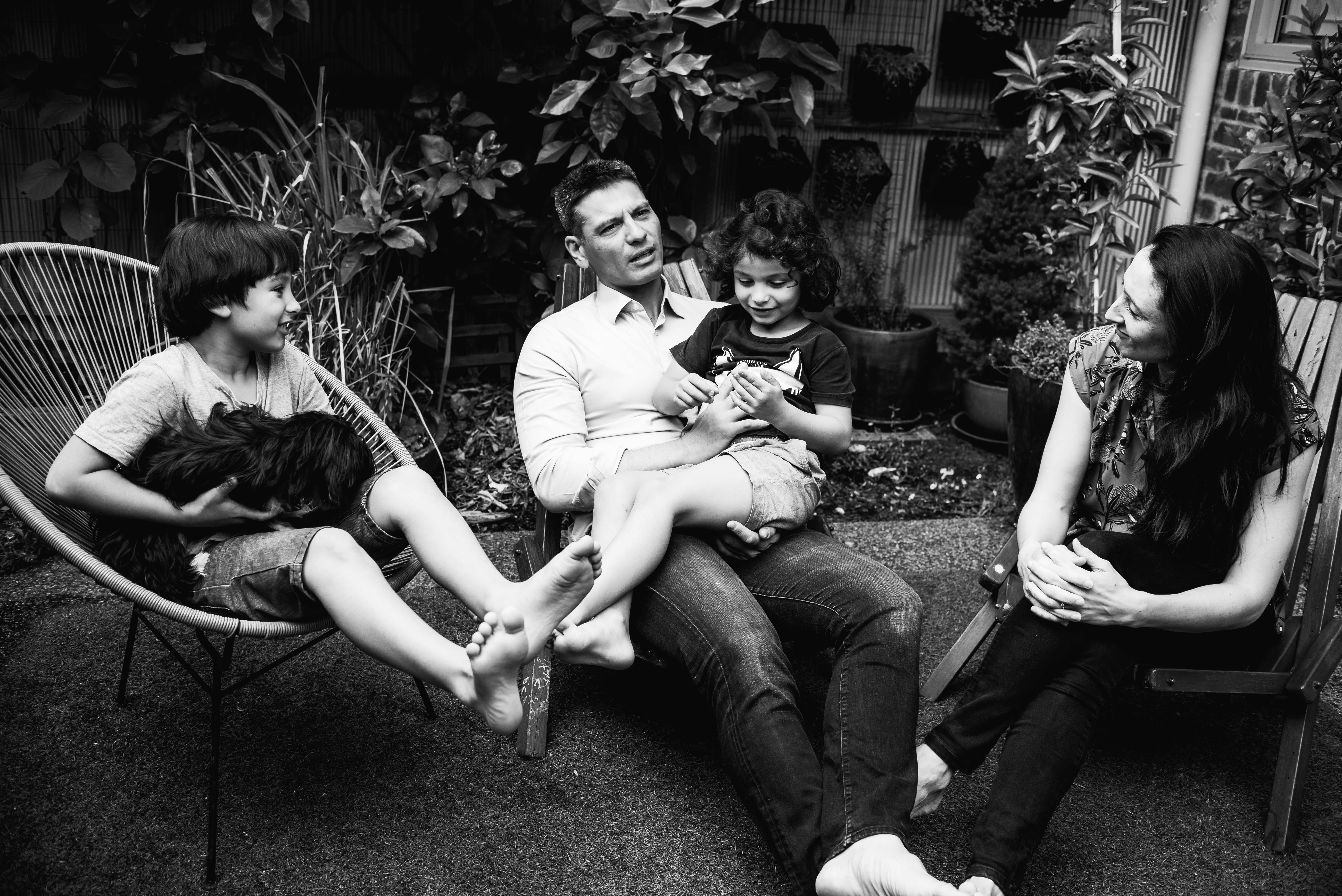 photograph of a family sitting in their backyard, talking in Carlton North, Melbourne, Australia